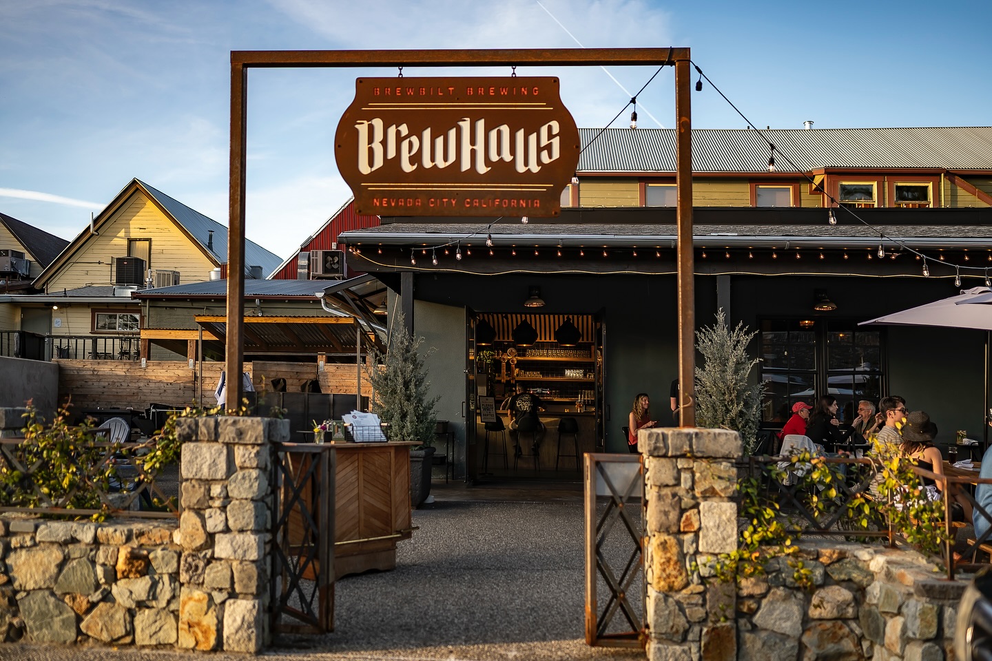 The lit BrewHaus sign over the patio entrance at dusk